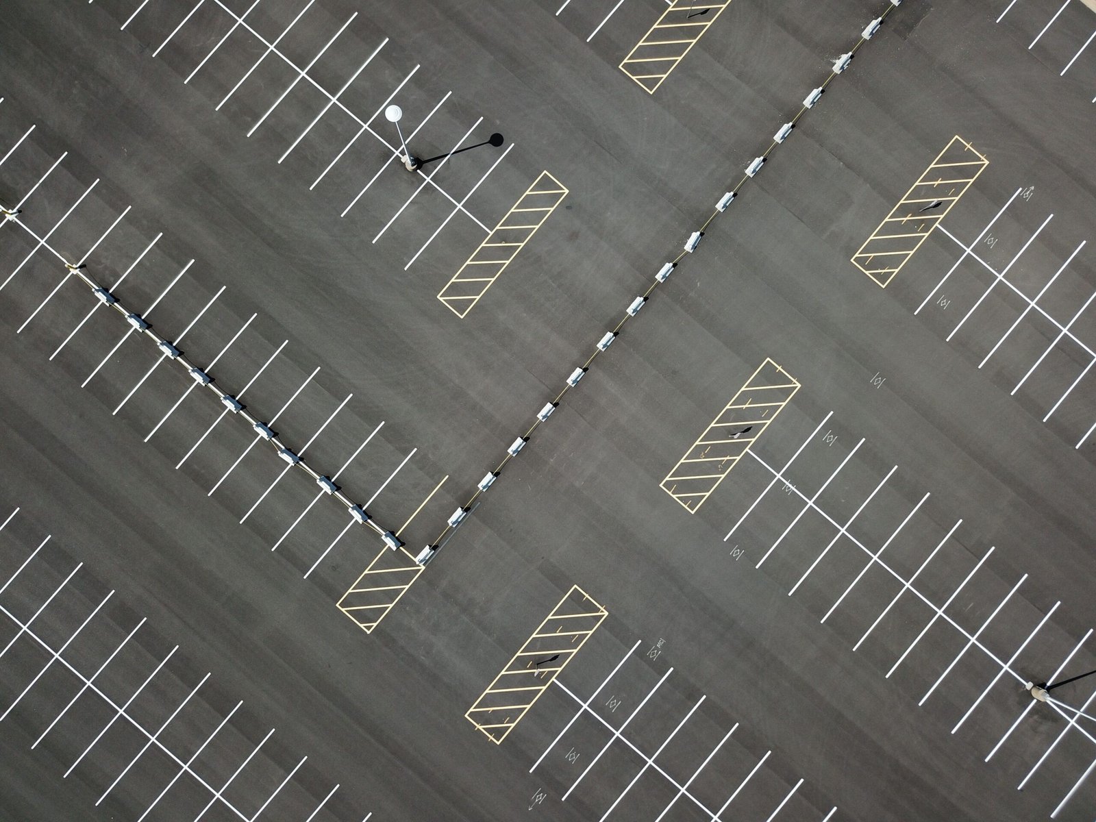 Top-down view of a large, empty parking lot featuring clear lines and patterns.